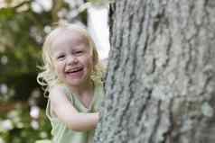 肖像快乐的女孩窥视树