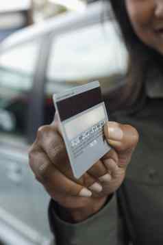 女人持有信贷卡在户外焦点前景