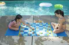 姐妹玩大国际跳棋董事会在游泳池边