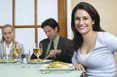 肖像成功的业务女人坐着餐厅表格的同事们背景
