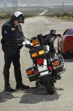 完整的长度交通警察写作票摩托车路