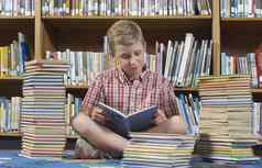男孩坐着地板上阅读书图书馆