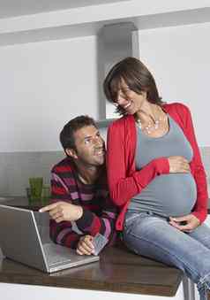 快乐年轻的怀孕了女人男人。在线购物