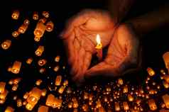 蜡烛光手浮动灯笼祈祷概念