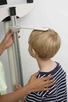 女护士测量男孩的高度诊所
