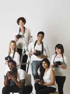 集团肖像年轻的摄影师坐着梯椅子