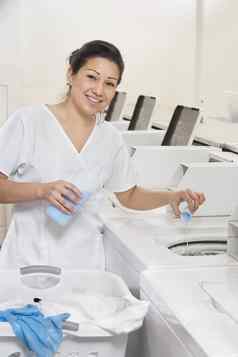 肖像快乐女人员工倒洗涤剂垫圈