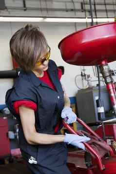 年轻的女机械师工作焊接设备