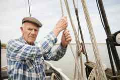 上了年纪的男人。持有绳子航行船