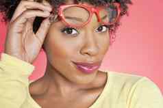 肖像非洲美国女人持有复古的眼镜彩色的背景