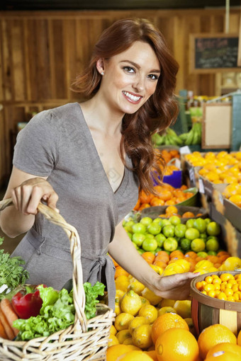 肖像快乐年轻的女人购物市场水果