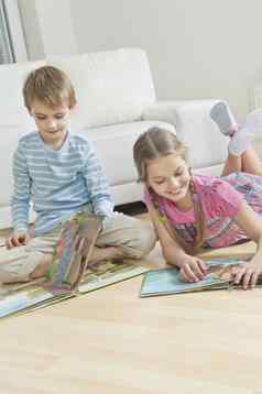 兄弟姐妹阅读故事书地板上生活房间