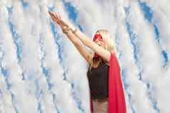 年轻的女人超级英雄装采取飞跃空气多云的天空