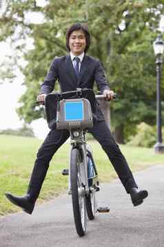 肖像年轻的商人骑自行车