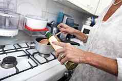 裁剪图像高级女人添加橄榄石油平底锅厨房计数器