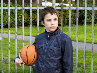 年轻的篮球球员持有球<strong>铁栅栏</strong>