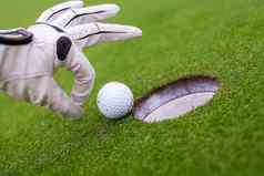 高尔夫球球员男人。推高尔夫球洞
