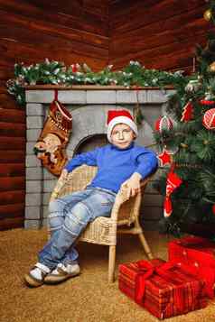 男孩坐在圣诞节树礼物