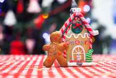 可爱的姜饼男人。前面糖果姜房子背景圣诞节树灯
