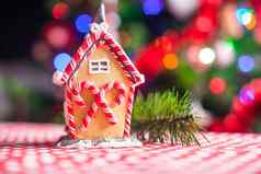 特写镜头姜饼仙女房子装饰色彩斑斓的糖果背景明亮的圣诞节树加兰