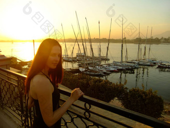 年轻的女人欣赏日落尼罗河河卢克索