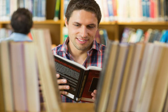 成熟的学生阅读书架子上图书馆