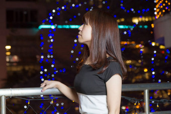 漂亮的亚洲女人前面城市灯