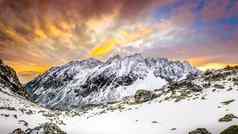 全景视图白色冬天山色彩斑斓的日落