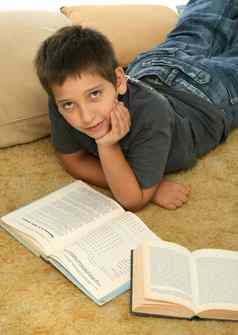 男孩阅读书地板上