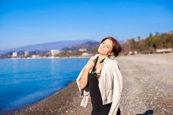 美丽的年轻的女人放松海滩冬天阳光明媚的一天