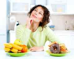 节食概念年轻的女人选择水果糖果