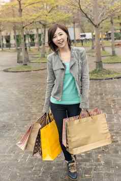 亚洲女人走持有购物袋