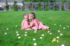 老妹妹接吻年轻的绿色草复活节鸡蛋