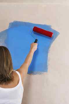 女人绘画墙油漆辊回来视图