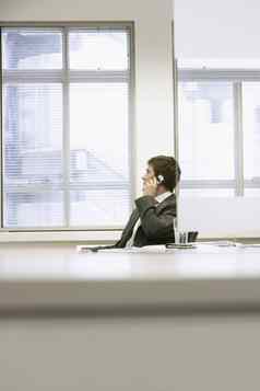 商人坐着办公室桌子上会说话的细胞电话