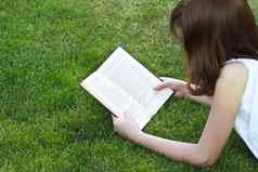 学生年轻的美丽的女孩阅读书户外
