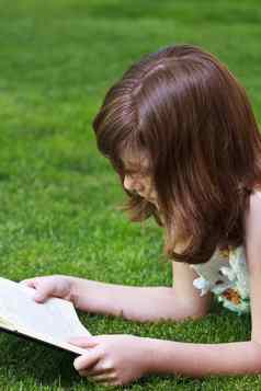 教育年轻的美丽的女孩阅读书户外