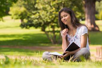 年轻的女人<strong>书笔</strong>坐着公园