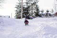 可爱的女孩拉雪橇温暖的冬天一天
