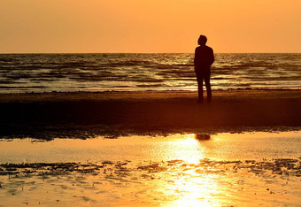 轮廓男人。海滩日落天空背景