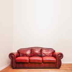 豪华的红色的皮革沙发上前面空白墙
