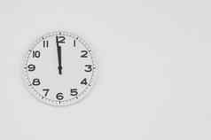 白色时钟黑色的手显示一分钟午夜中午