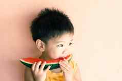 可爱的亚洲男孩吃西瓜