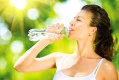 健康的运动年轻的女人喝水瓶