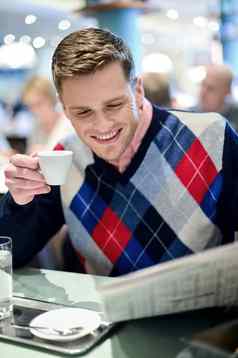 时尚的男人。阅读报纸户外咖啡馆