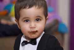 可爱的快乐婴儿吃巧克力穿西装弓领带