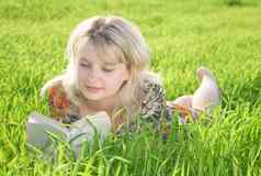 年轻的美丽的女孩阅读书户外