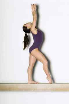 体操运动员摆姿势平衡梁一边视图