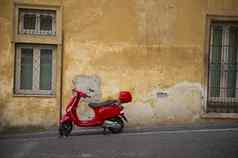 明亮的红色的维斯帕踏板车城市街