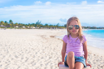 可爱的女孩坐着莲花位置异国情调的海滩